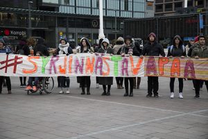Ensimmäisen vuoden yhteisöpedagogiopiskelijat seisovat Kampissa #SyrjinnästäVapaa -kyltin kanssa.