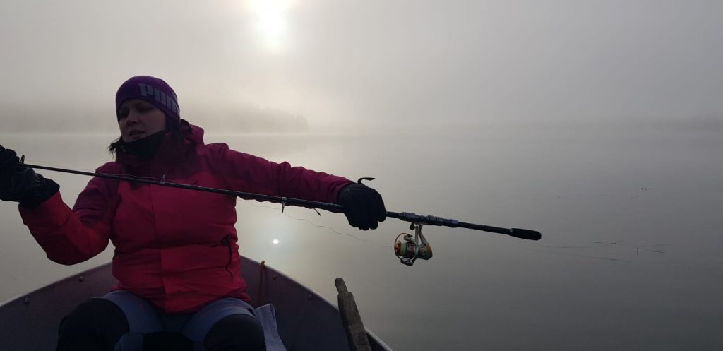 Nainen kalastamassa sumuisena aamuna
