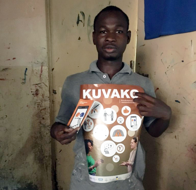 Kuuro mies esittelee Kuvako-hankkeen esitteitä Senegalissa.