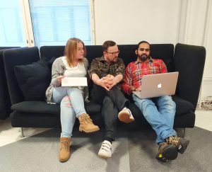Kolme opiskelijaa istuu sohvalla ja lukevat tietokoneelta.