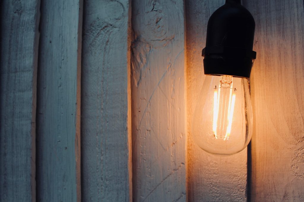 a lightbult against a wooden wall.