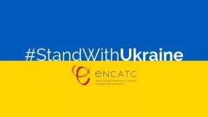 Kuvassa Ukrainan lippu ja sen päällä teksti: #StandWithUkraine. Encatc.