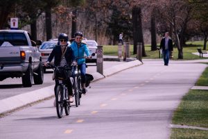 Kaksi pyöräilevää henkilöä kaupunkiliikenteessä.