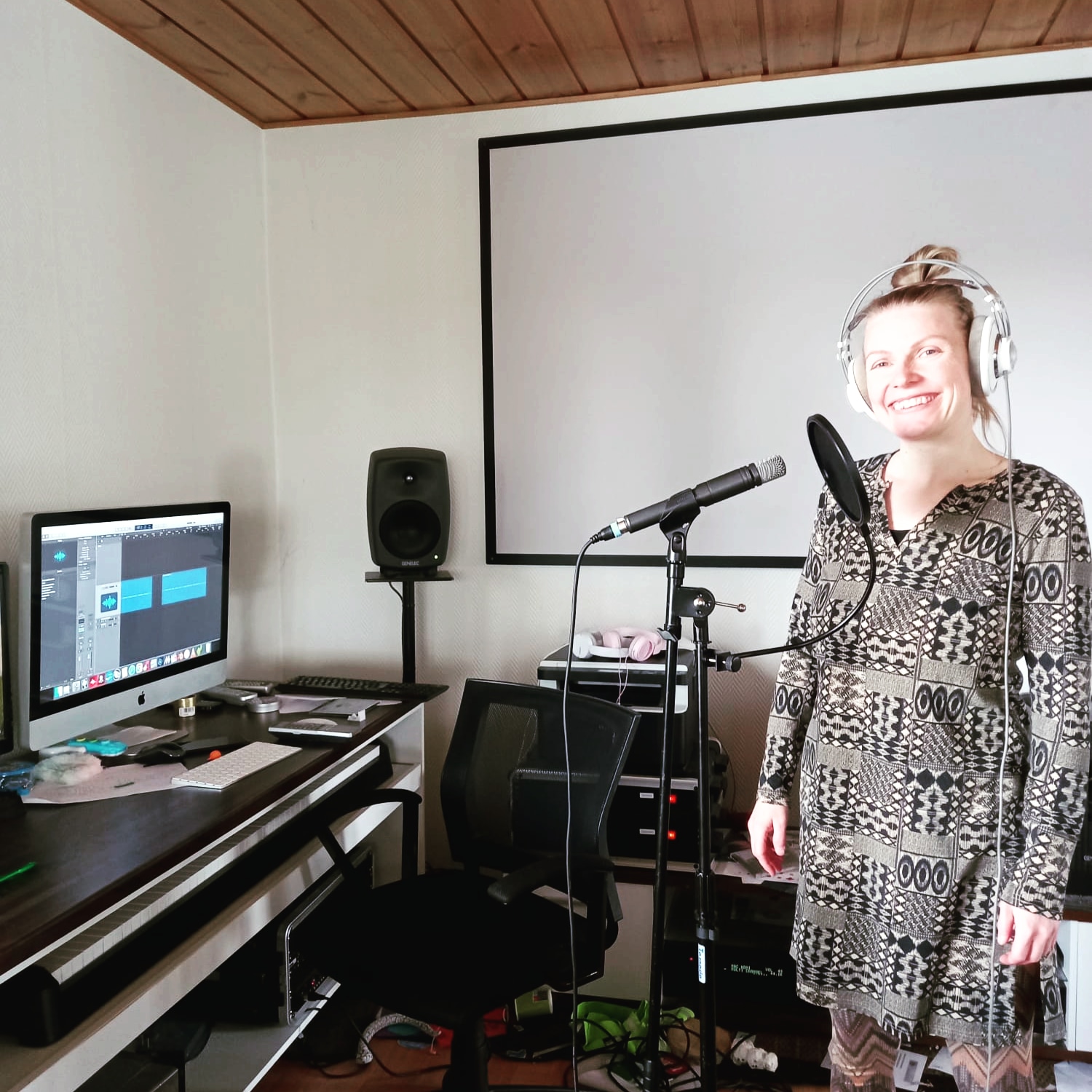 Taiteilija-käsikirjoittaja Laura Rukola seisoo äänitysstudiossa ja nauhoittaa etäelämyksen osallistavaa taidepistettä.