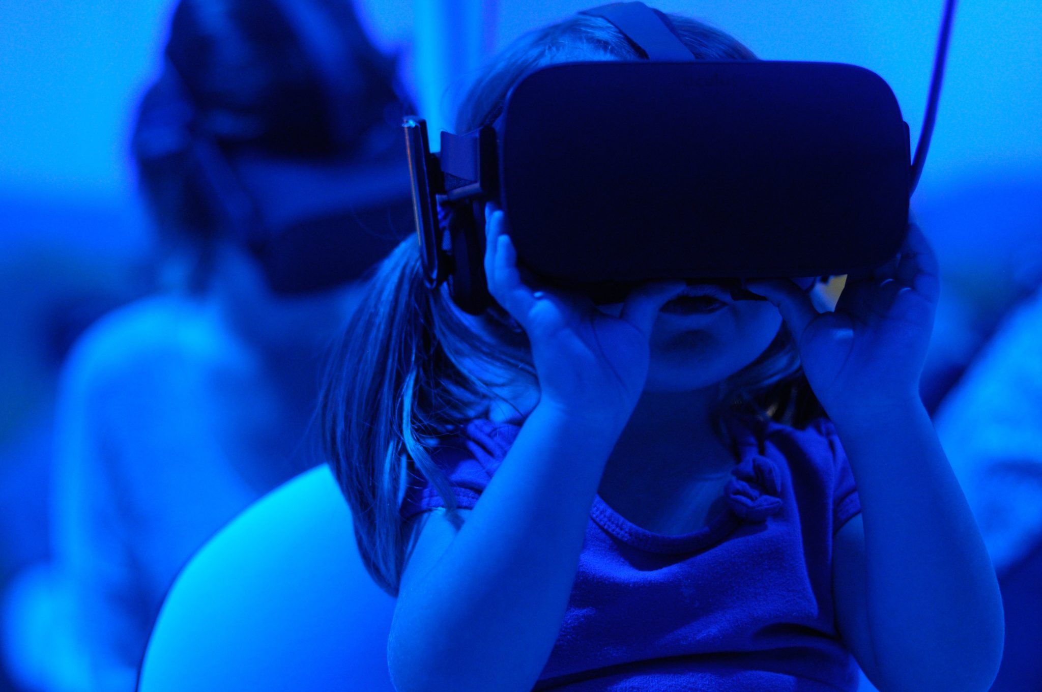 Pienellä lapsella on VR-lasit päässä ja hän näyttää keskittyneeltä.