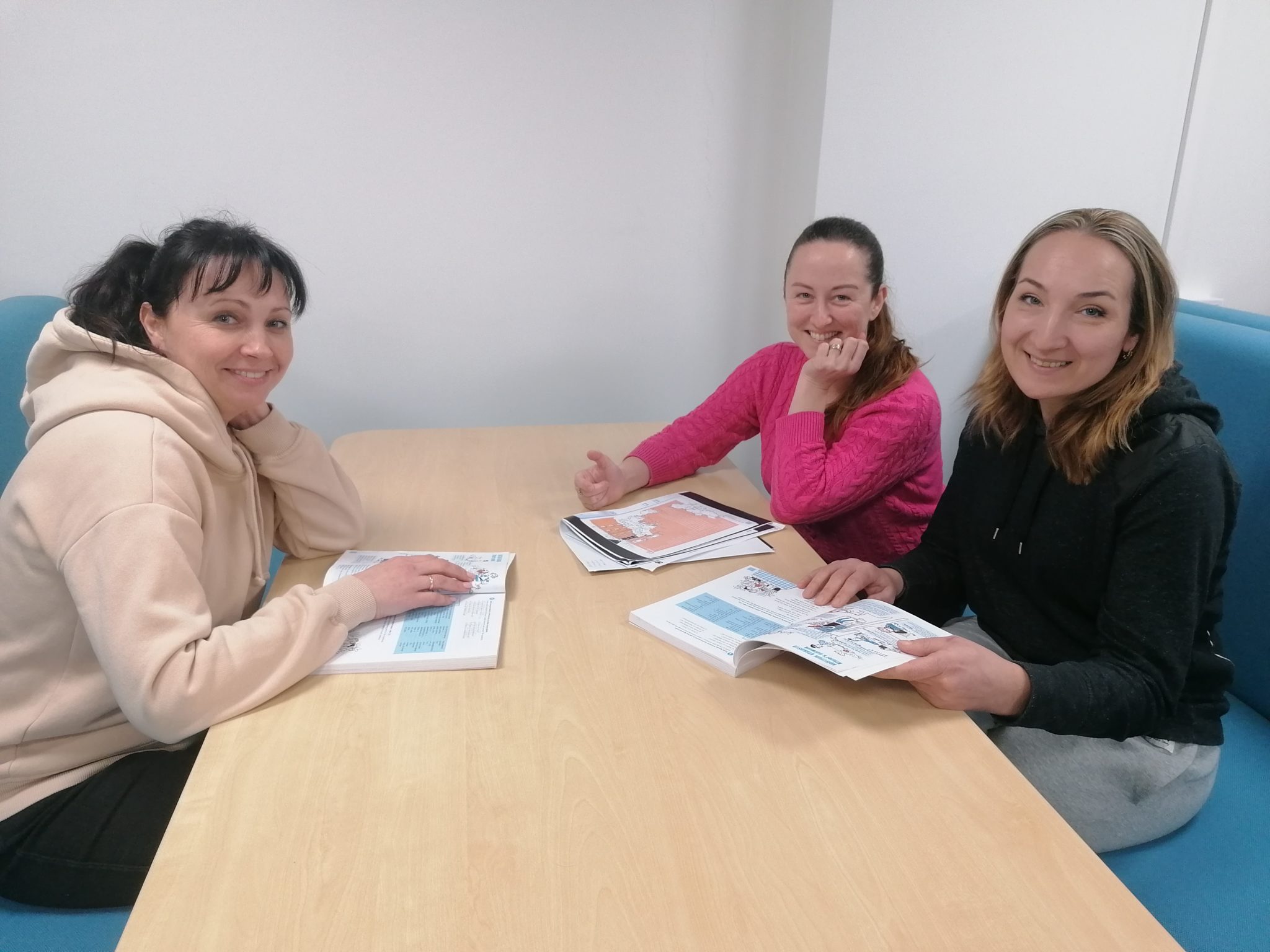 Natalia Pendiura, Nataliia Lalabekova and Olha Mykhailova are smiling with their finnish textbooks)