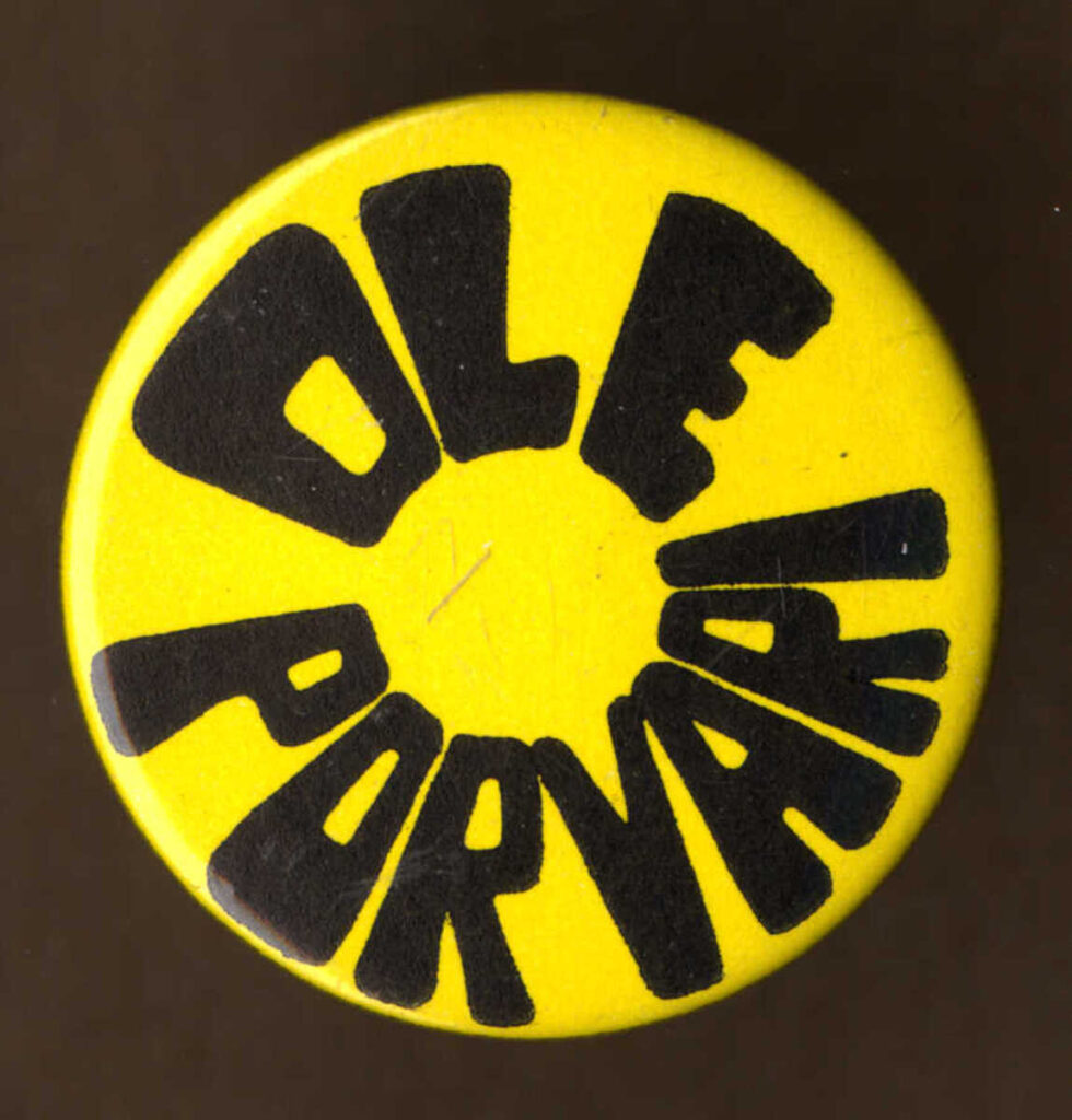 Kuvassa keltaisella pohjalla oleva pyöreä rintanappi, jossa mustalla teksti ”Ole porvari”.