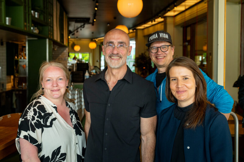 Neljä henkilöä poseeraa ja hymyilee kameralle.