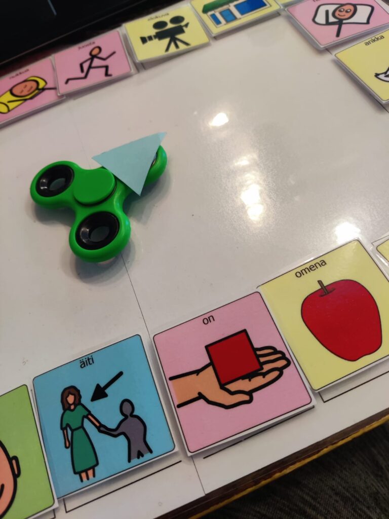 pöydällä kuvia ja niiden keskellä widgedspinner, jota pyöräyttämällä spinnerissä oleva nuoli osoittaa jotakin kuvaa.