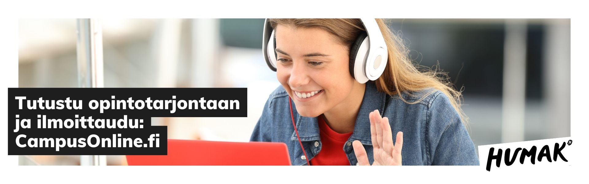 Nainen, jolla on valkoiset kuulokkeet, siittoo kädellään kohti läppärinsä ruutua hymyillen. 