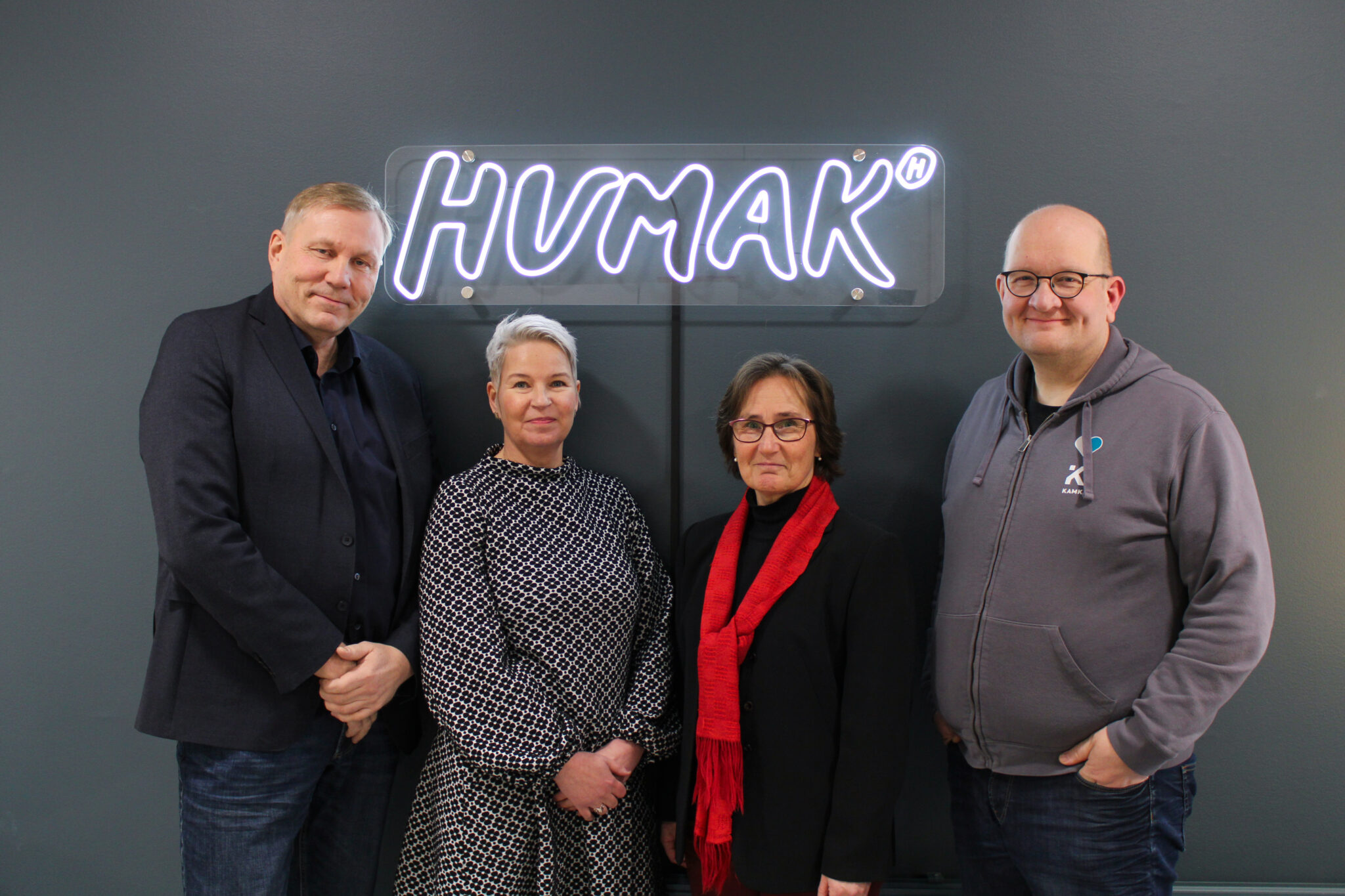 Neljän kokreakoulun rehtorit yhteiskuvassa Humakin tiloissa. He hymyilevät kameralle iloisesti.