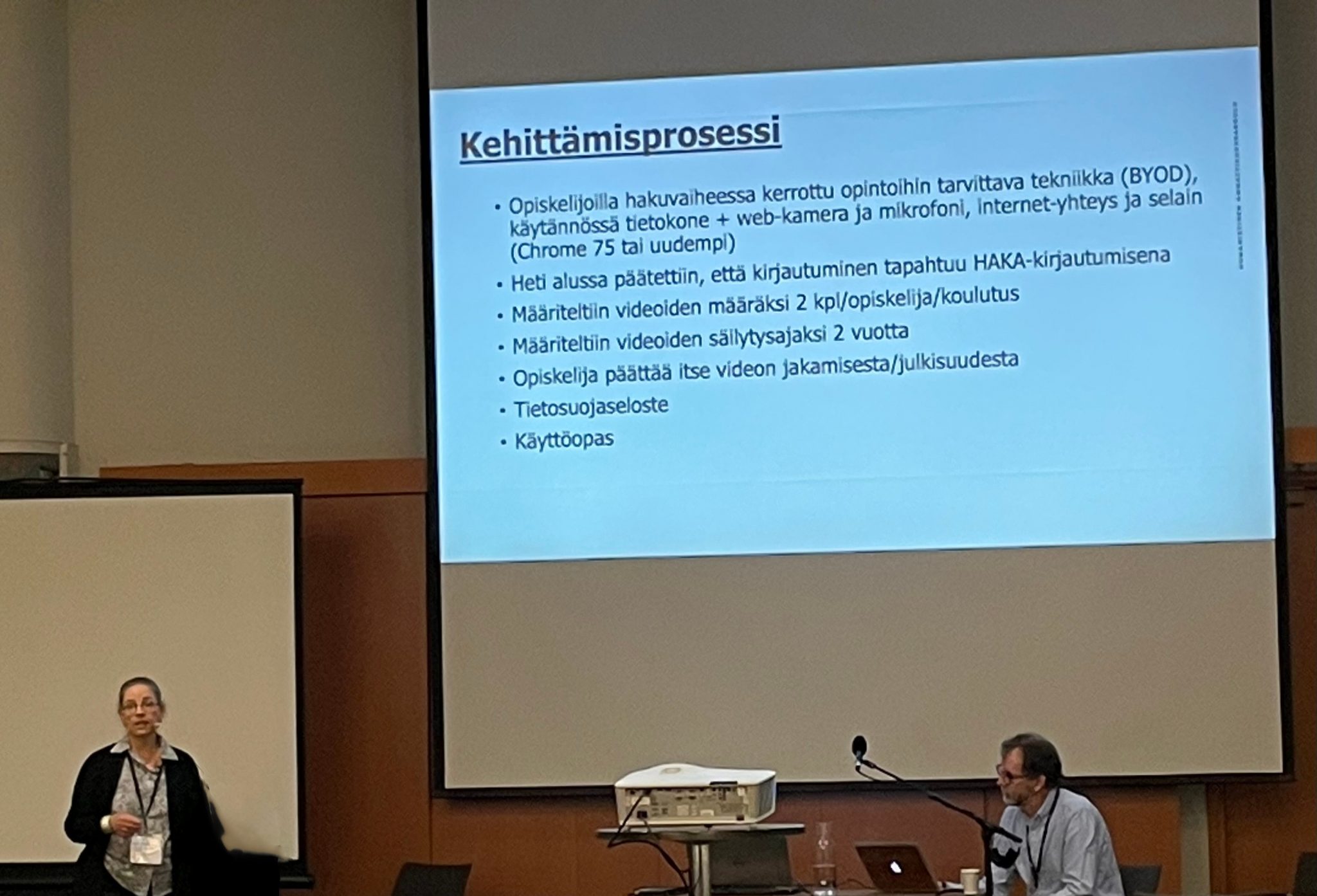 Vasemmalla alareunassa Merja Kylmäkoski, oikealla Scott Alexander. Taustalla diaesitys, jossa kerrotaan Virpin kehittämisprosessista.