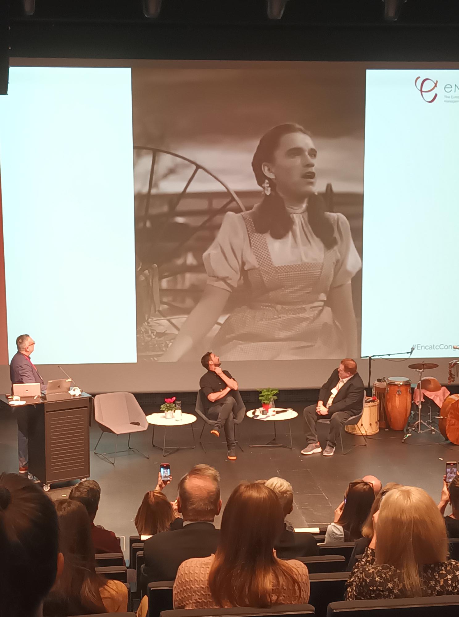 Yleisö seuraa elokuvaa Ihmemaa Oz, jossa Judy Garlandin esittämän Dorothyn rooliin on vaihdettu Arnold Schwarzenegger.