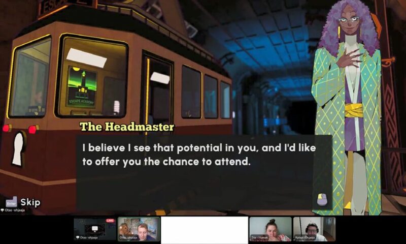 Näyttökuva videopuhelusta, jossa pelataan peliä ja alareunassa ohjaajien videoruudut. Pelissä näkyy juna ja hahmo, jolla on pitkät kiharat hiukset ja vihreä‑kuvioinen pitkä takki. Ruudulla on teksti: “The Headmaster – I believe I see that potential in you, and I’d like to offer you the chance to attend.”