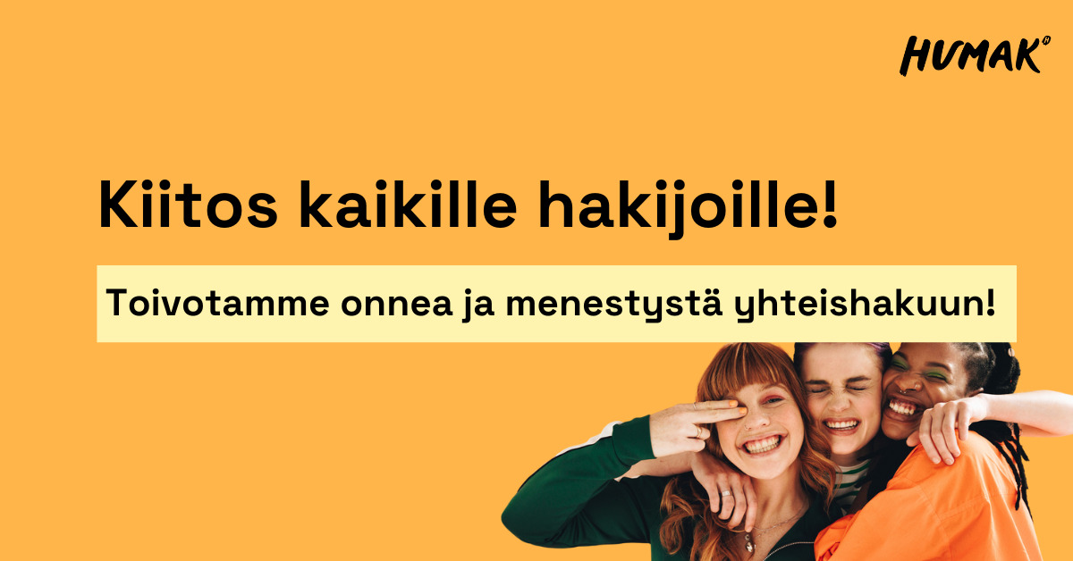 Oranssilla taustalla hymyileviä nuoria naisia, jotka halaavat ja poseeraavat kameralle.