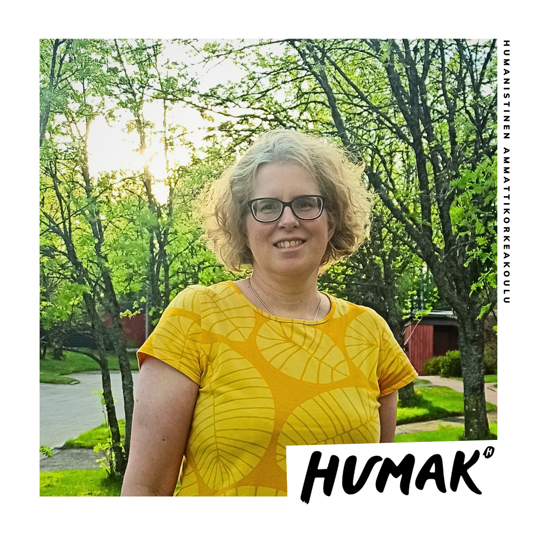 Heidi Katila seisoo aurinkoisella pihalla ja katsoo suoraan kameraan hymyillen.