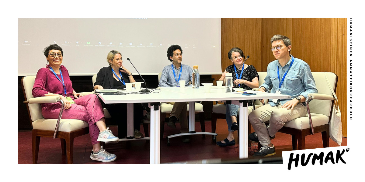 Five persons sitting around a table having a lively discussion