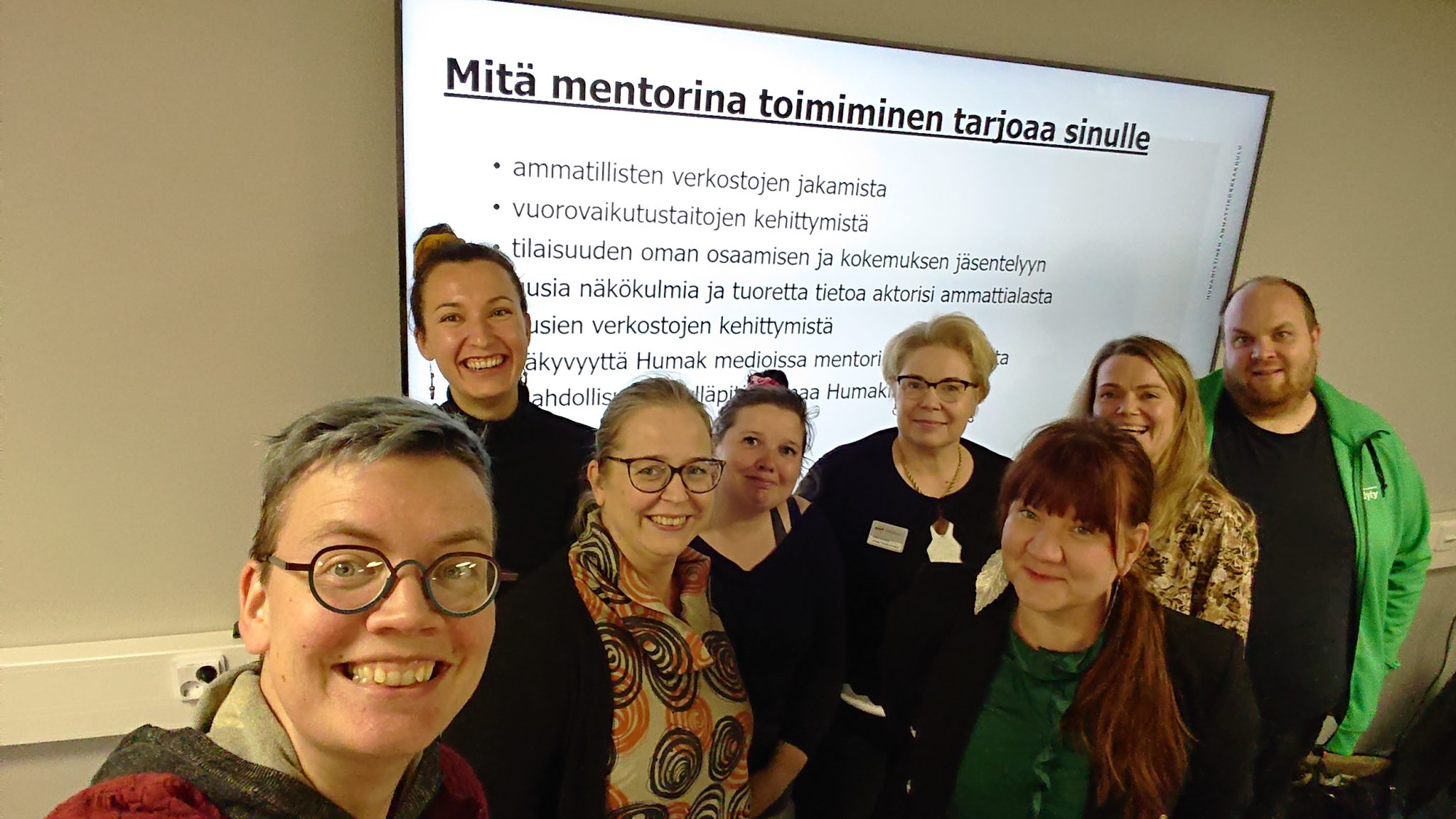 Alumnit ja lehtorit poseeraafat selfiessä dian "Mitä mentorina toimimnen tarjoaa sinulle edessä?".
