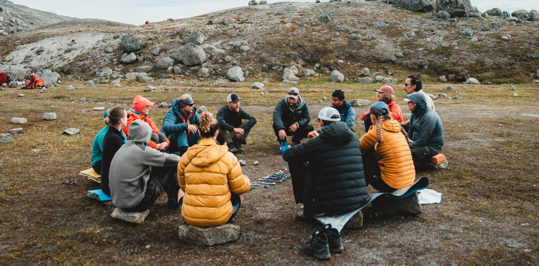 Seikkailukasvatuksen opiskelijoita kokoontuneena kuuntelemaan ohjeistusta kiipeilyvarusteista.