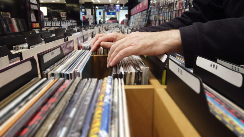 Close up of hands flipping through lps in a large record shop.