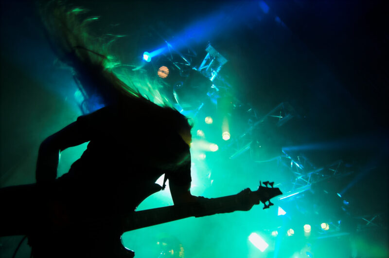 Silhouette of heavy metal guitar player performing live