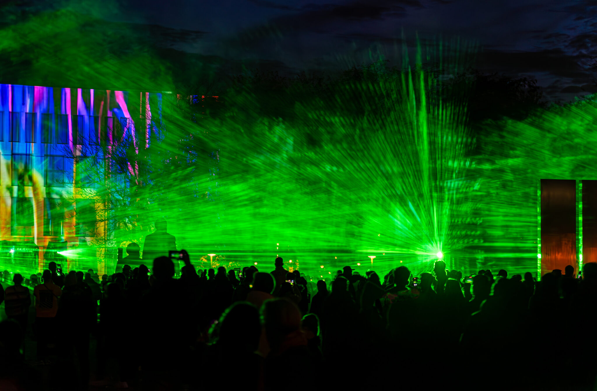 Germany, Berlin, Berlin City Palace, October 12, 2024 -Silhouette of large group of people at a Laser Show in front of Berlin City Palace - at Berlin Festival of Lights