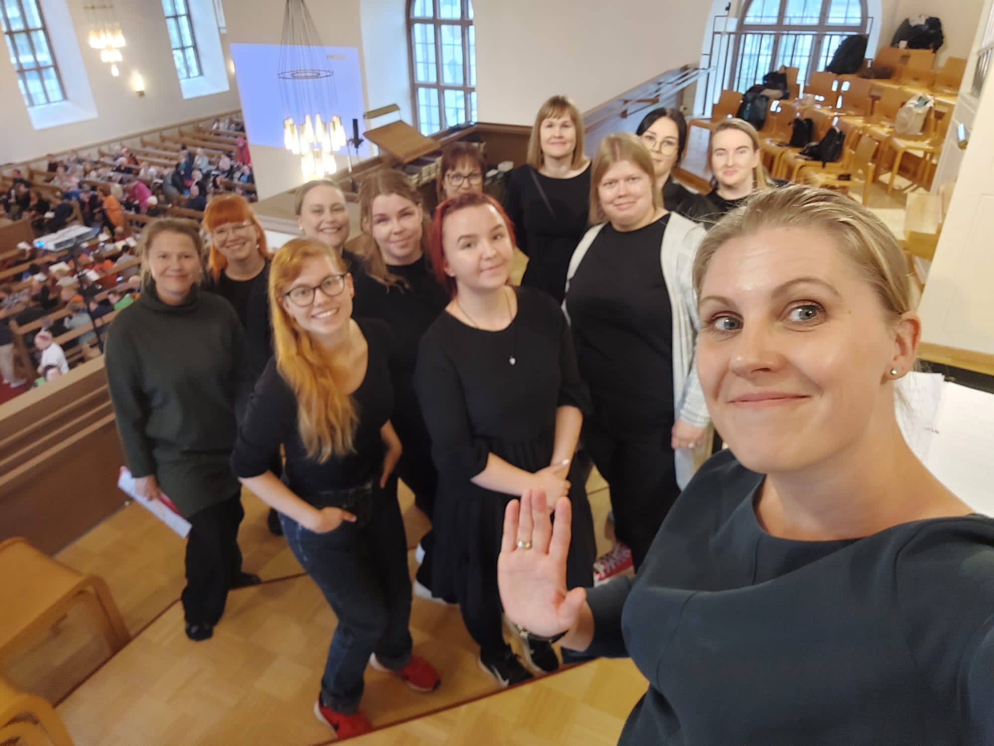 Kymmenkunta naispuolista tulkkauksen opiskelijaa hymyilee kameralle selfiessä.