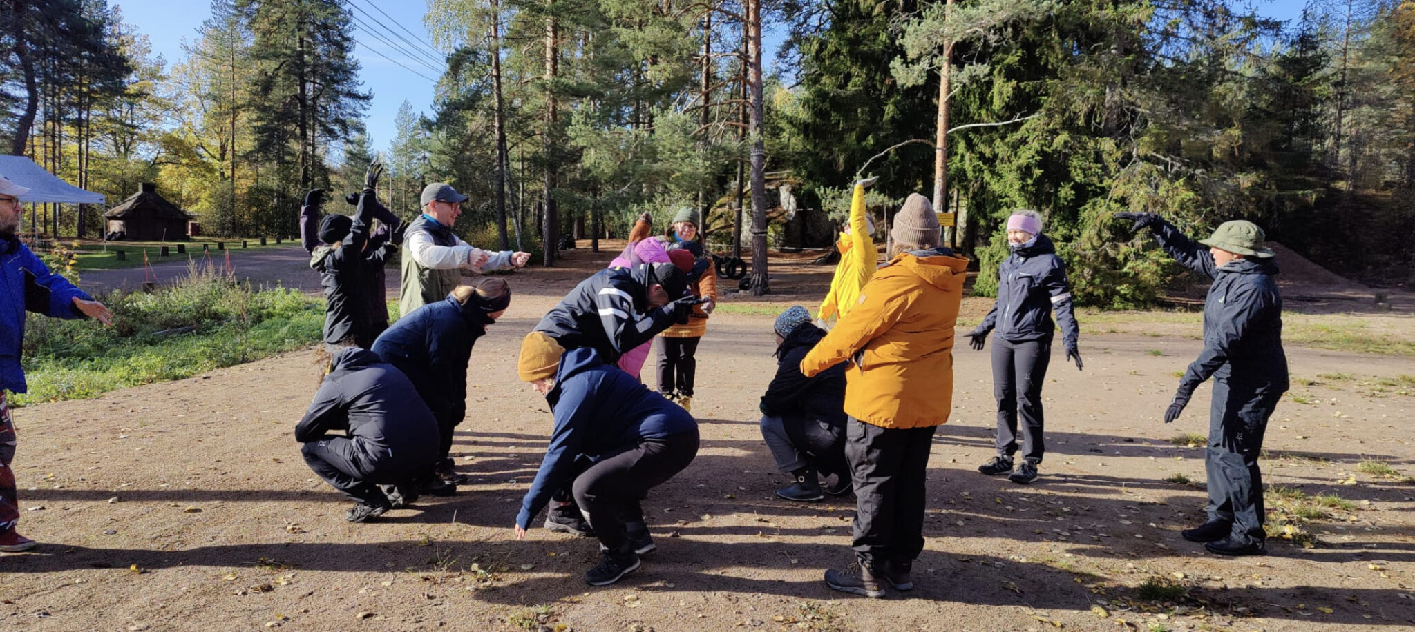 Joukko opettajia osallistumassa ryhmäaktiviteettiin luontoympäristössä. 
