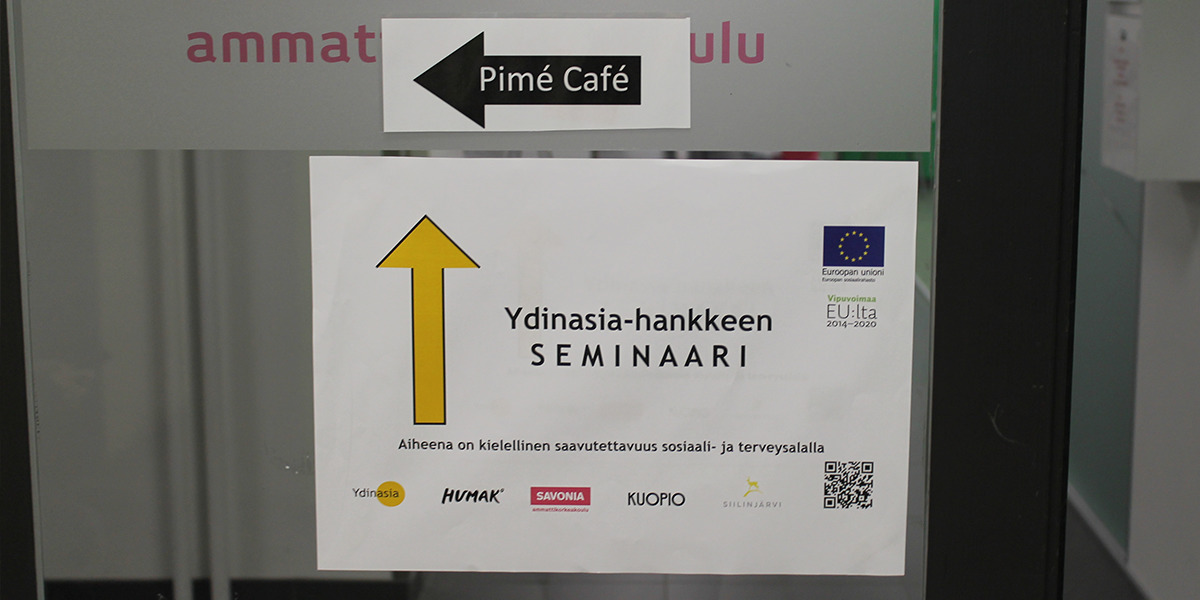 Oveen on laitettu nuolella varustettu Ydinasia-hankkeen seminaarin esite.