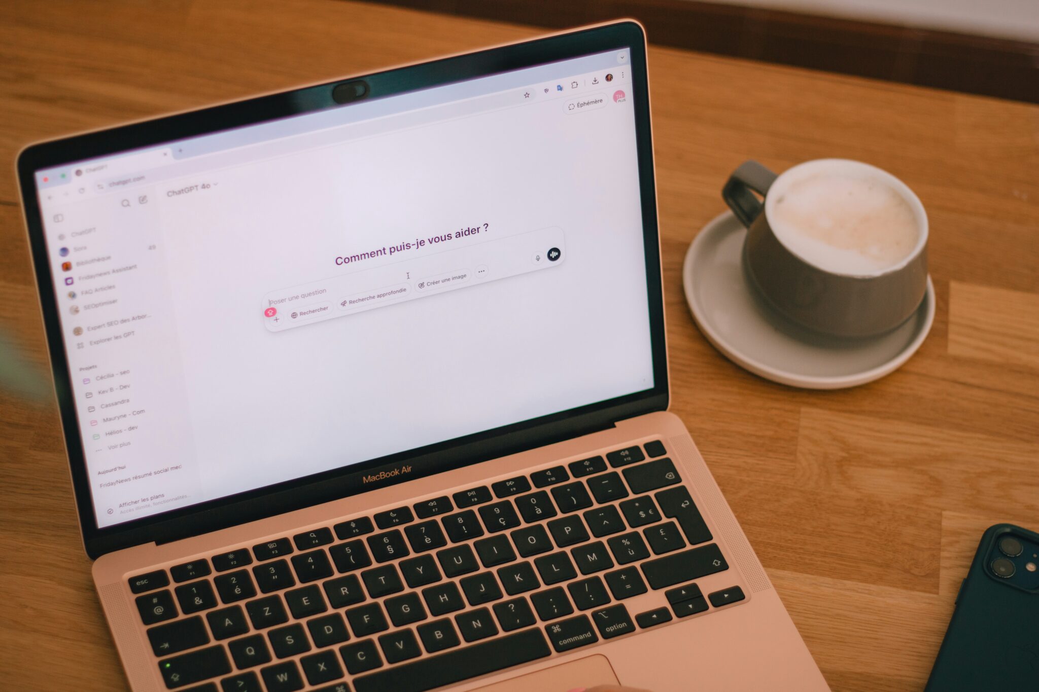 Kuvituskuva, jossa kannettava tietokone ruutu auki, ruut valkean, pientä tekstiä, näppäimistö näyy kuvan alareunassa osittain. Pöydällä kannettavan tietokoneen vieressä kahvikuppi, vaahtoavaa maitokahvia.