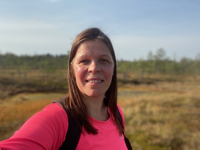 Selfie hymyilevistä kasvoista. Taustalla suo-maisema.