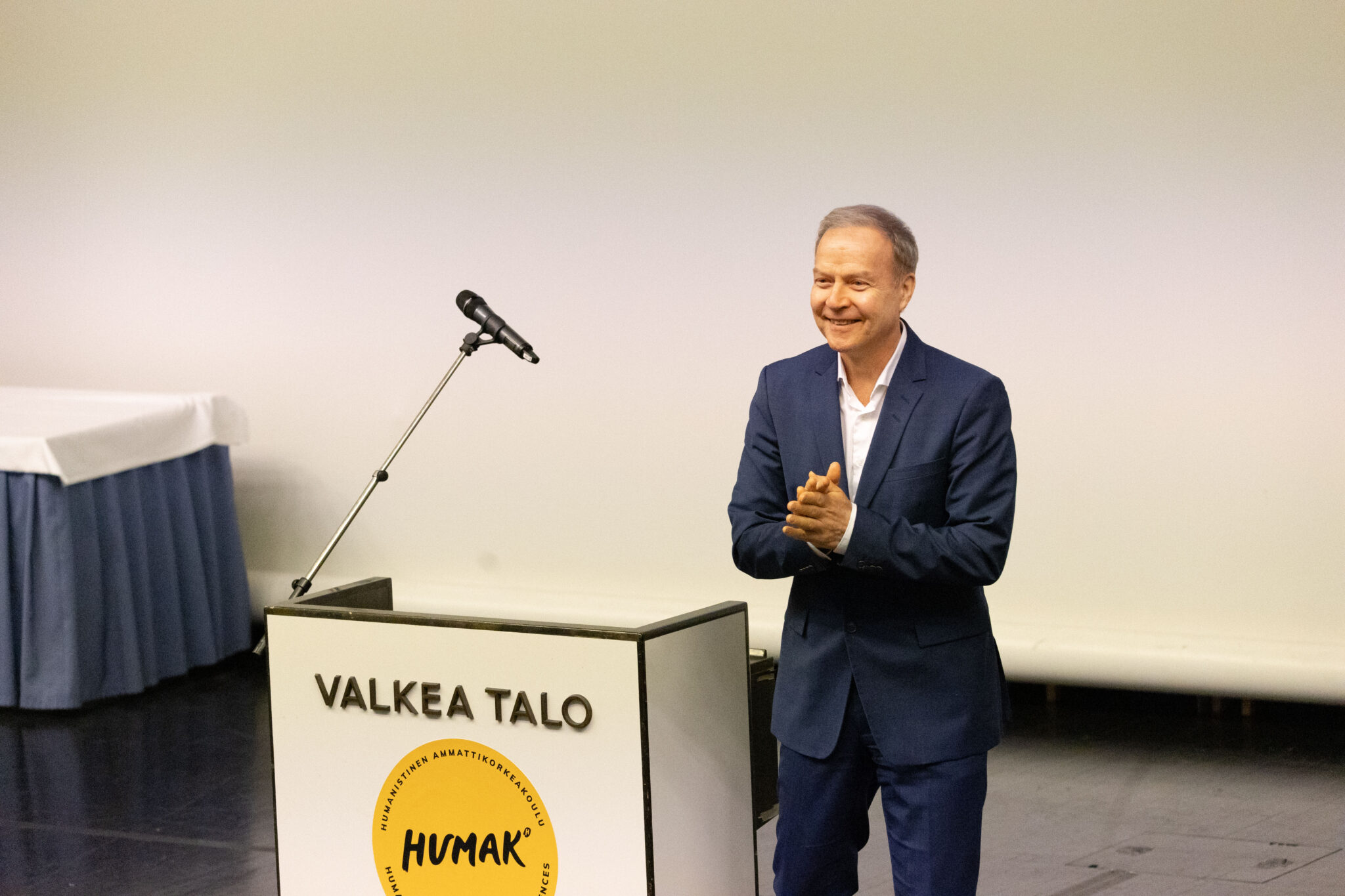 Puhuja hymyilee tyytyväisenä Valkean talon auditoriossa.