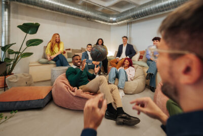 Group of young colleagues relaxing and playing with a basketball in a modern office during a break