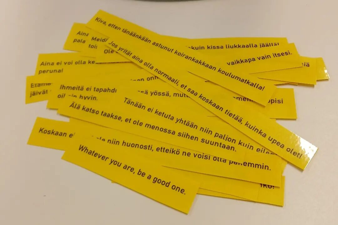 Keltaisia lappuja pöydällä, joissa on tsemppiviestejä.